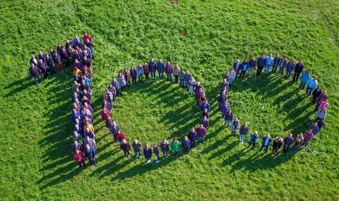 Die Zahl 100 in Form mit Personen dargestellt