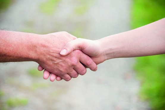 Zwei Menschen reichen sich die Hand - Handschlag